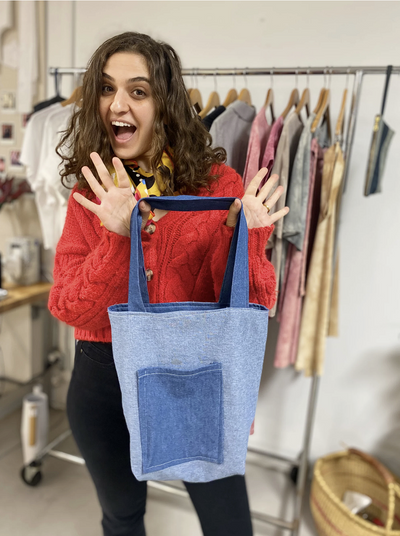 Student holding a zippered pouch in a beginner sewing class at Moving Thread LA